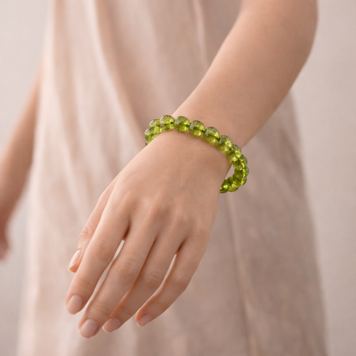 Green beaded bracelet on a person's wrist against a neutral background